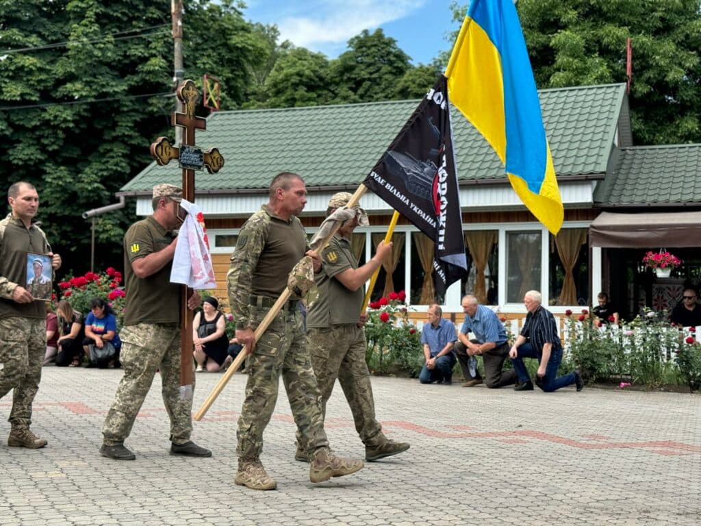 Побратим оплакує загиблого воїна і несе прапор його 72-ї бригади. Володимир Тур – на щиті. Володимир Тур загинув