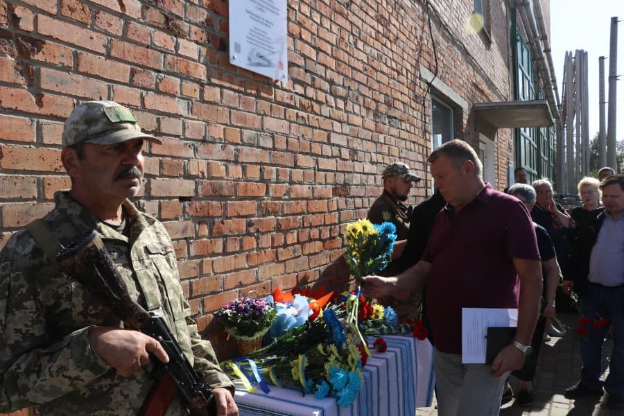 Люди кладуть квіти до меморіальної дошки. Фото Полтавської міської ради.