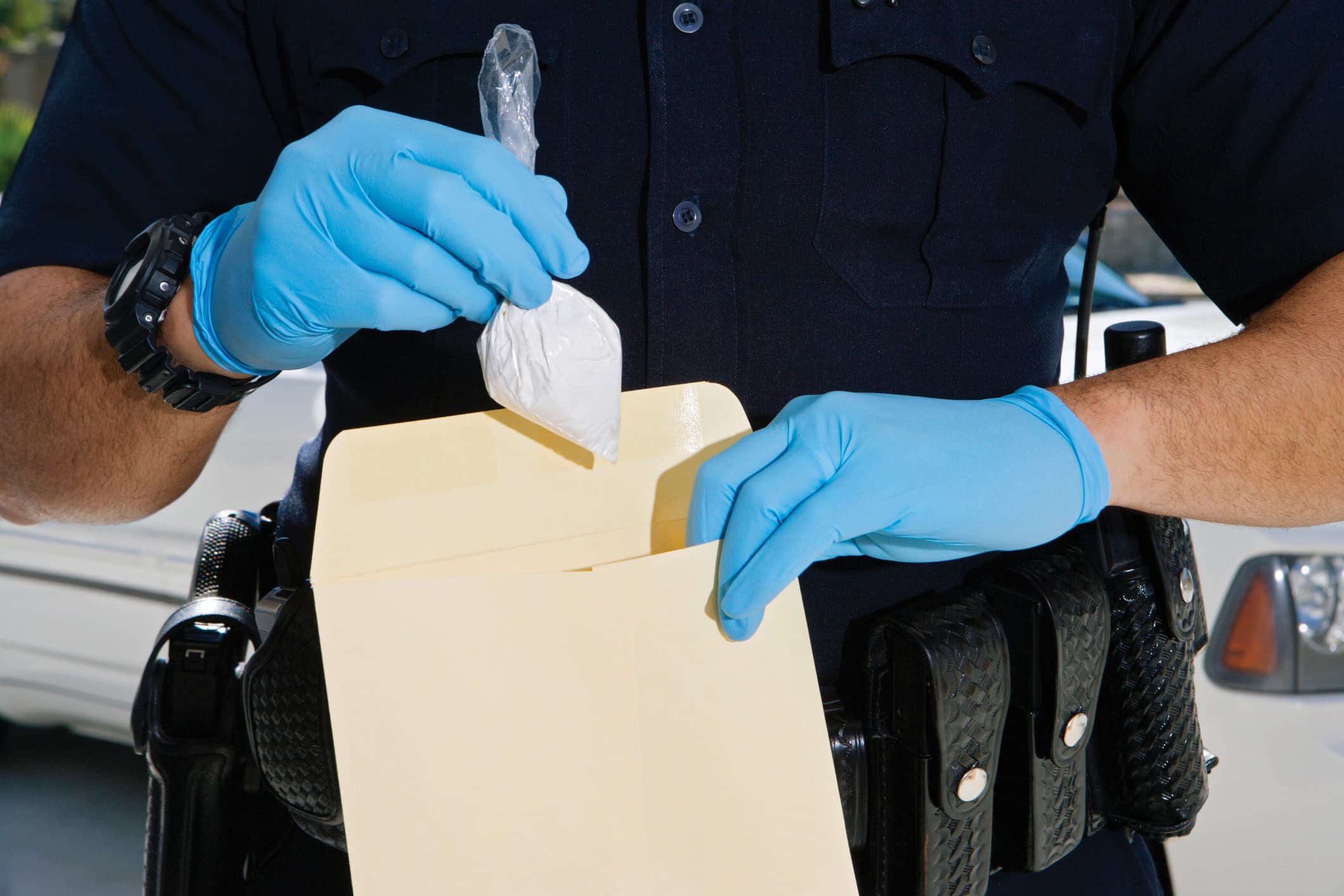 Police Officer Putting Cocaine in Evidence Envelope