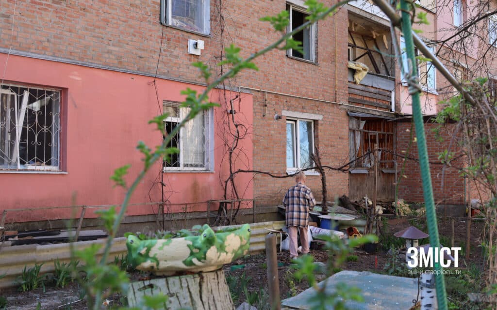 Постраждала від обстрілу жінка порається у квітнику