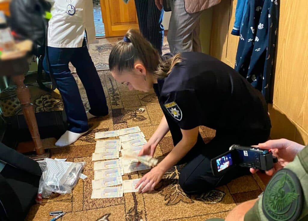 Слідча розкладає вилучені у фігурантів з ВЛК грош. Хабар влк