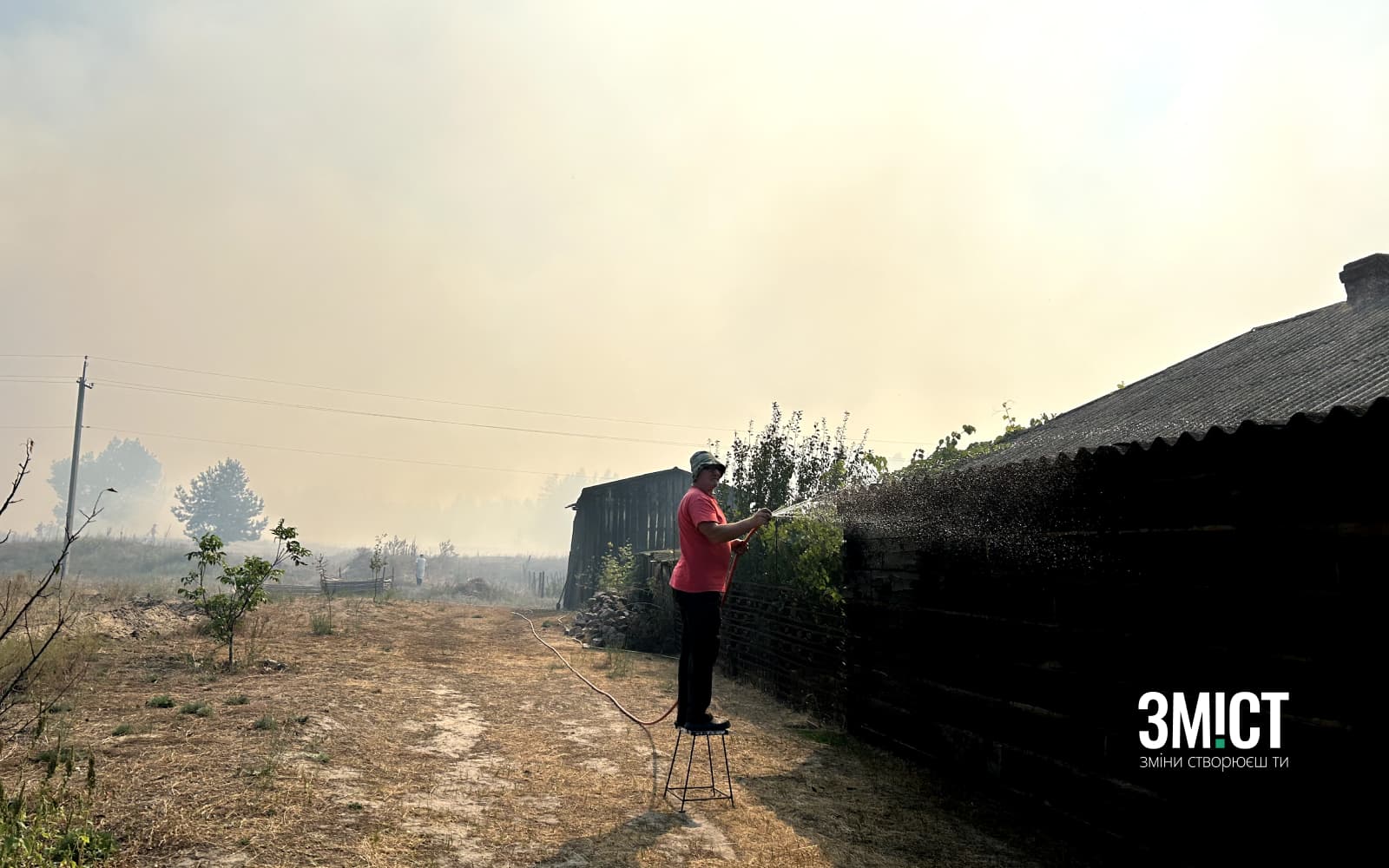 Місцевий поливає свій будинок, аби врятувати його від пожежі